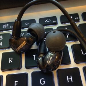 Shure se 215 black iem standing on laptop keyboard